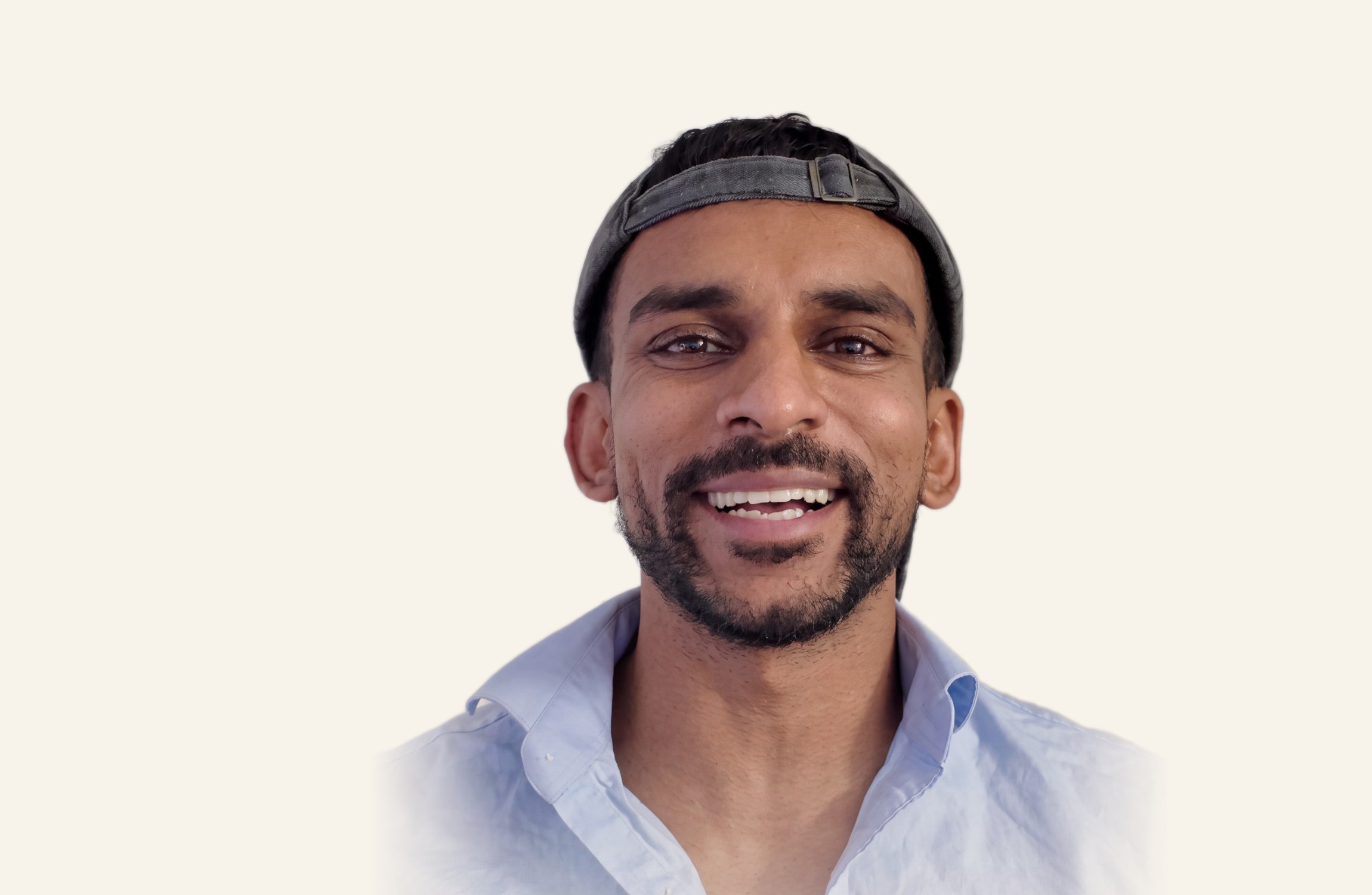 Gin smiling at the camera in a light blue shirt and cap
