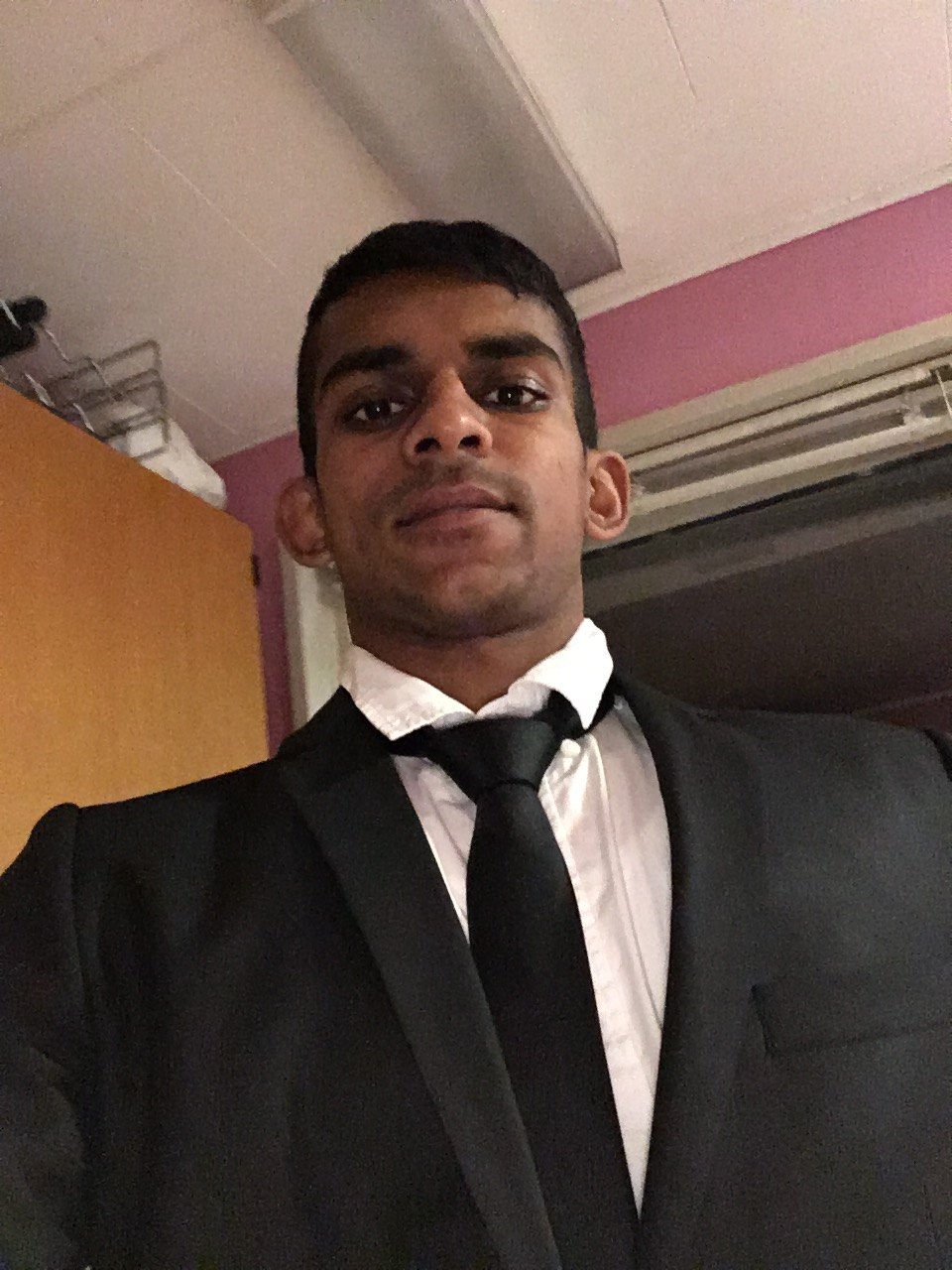 A younger Gin in a black suit and tie, 2016