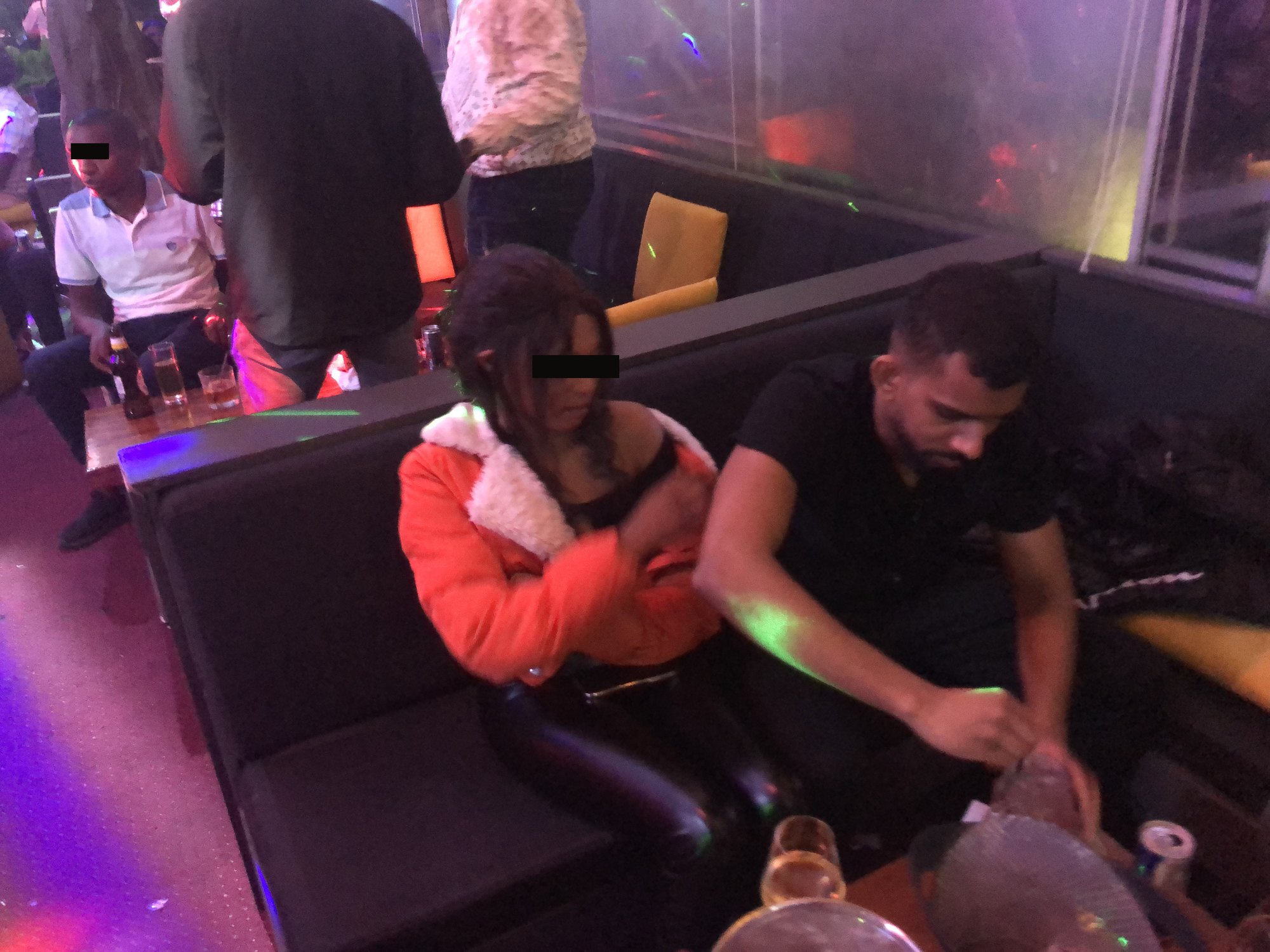 Gin in a nightclub booth, another guest's face blurred