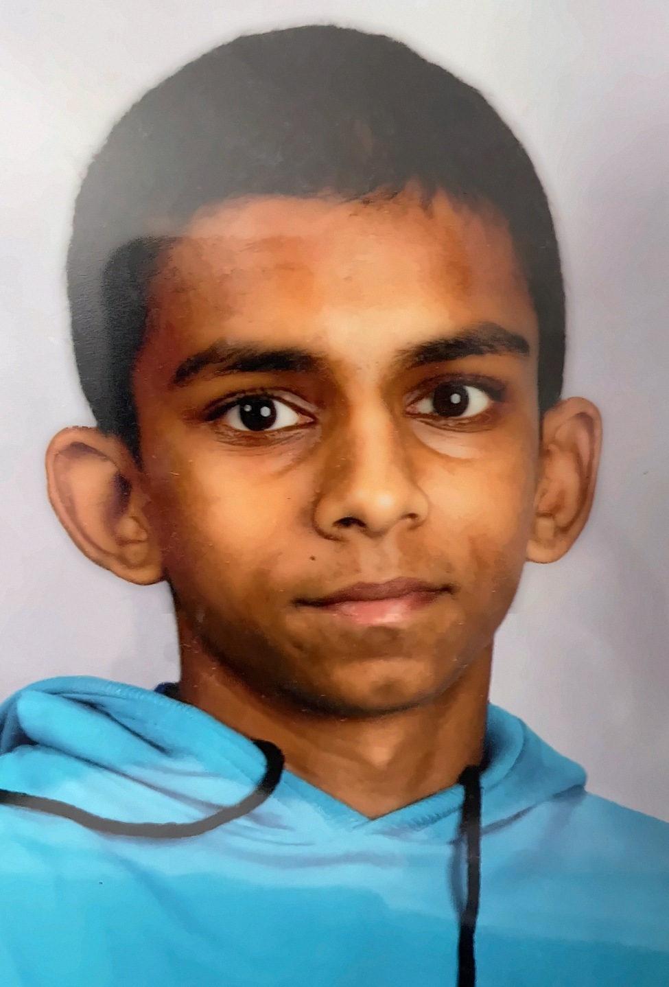 Gin as a teenager in a blue hoodie, school photo