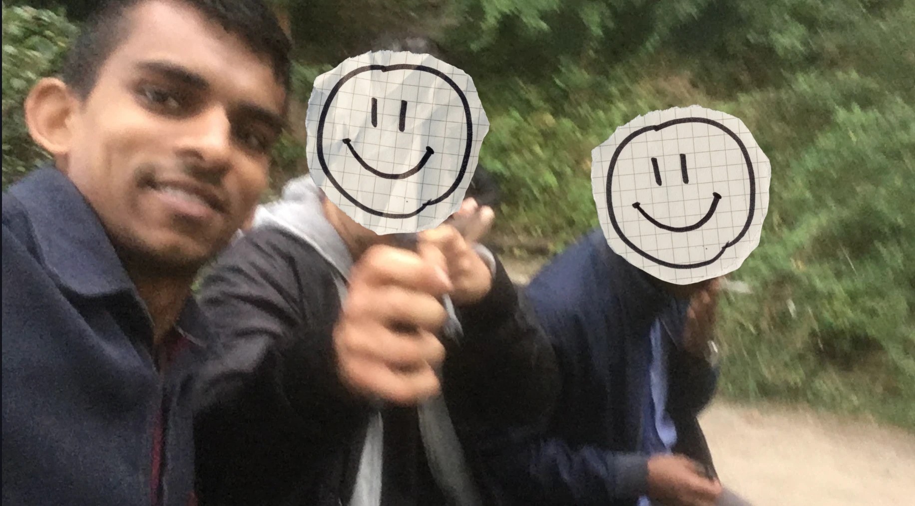 Gin with two friends whose faces are covered by paper smileys